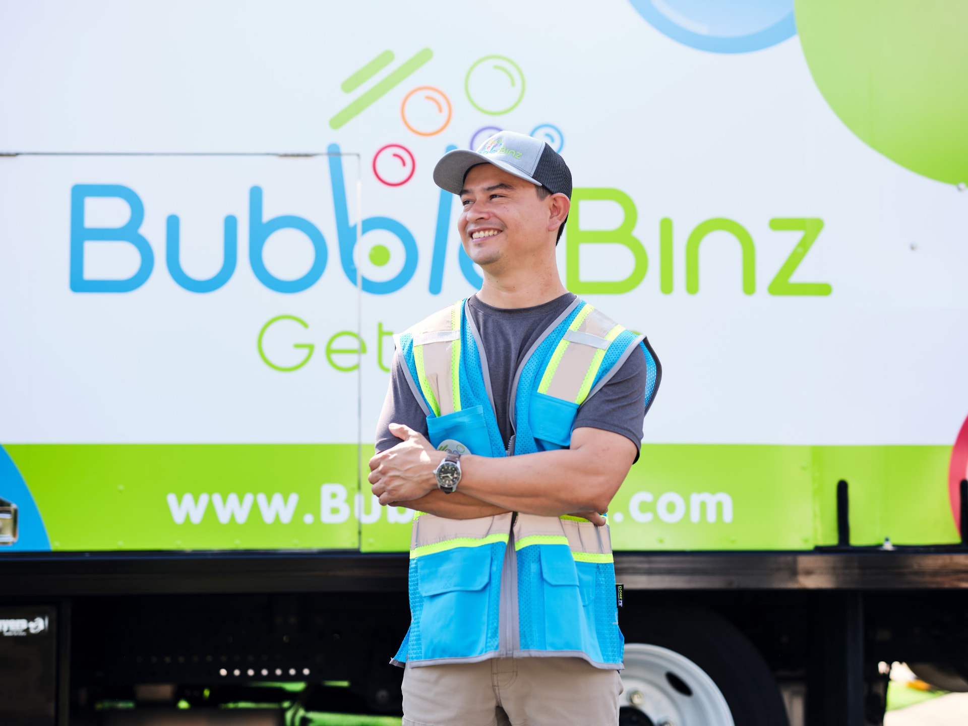Smiling Bubble Binz technician in front of a branded truck