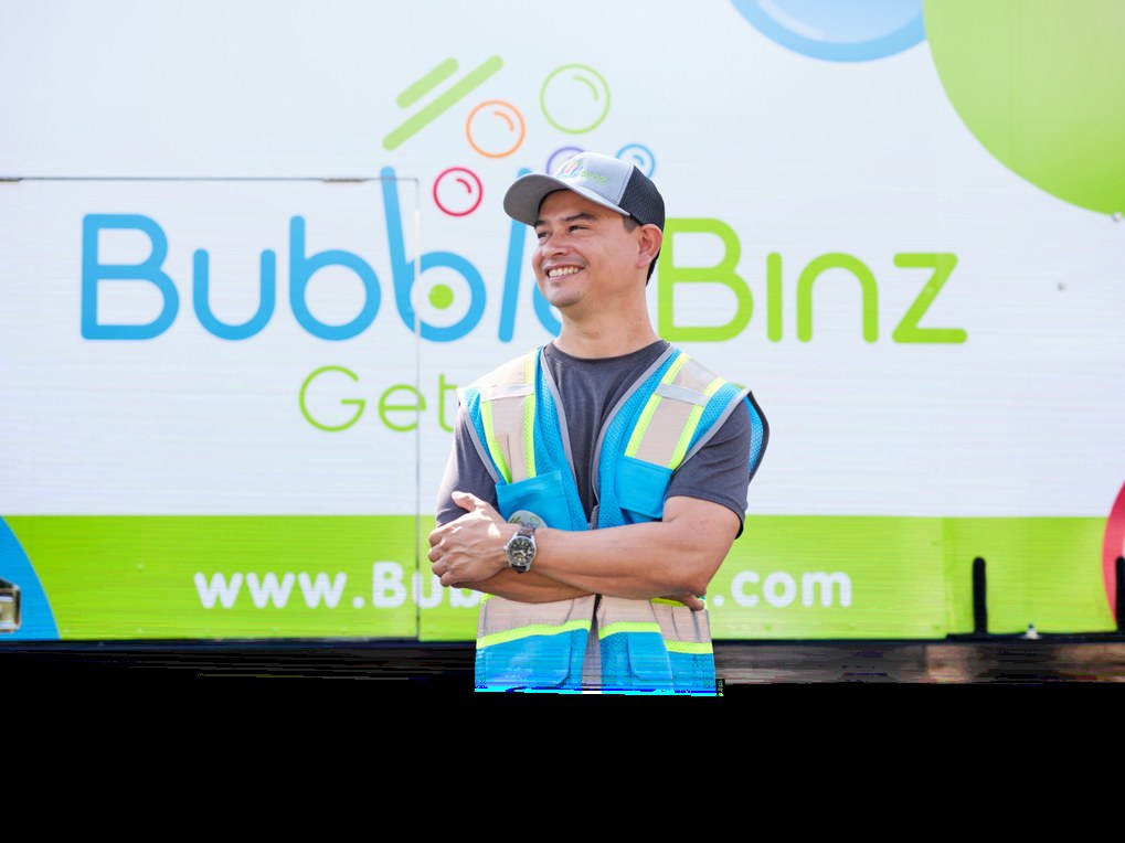 Smiling Bubble Binz technician in front of a branded truck