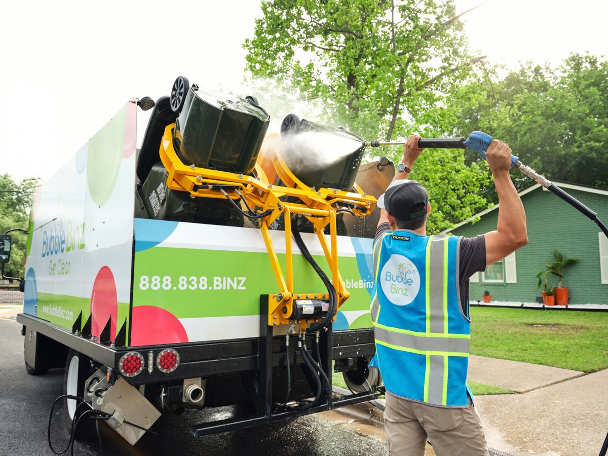 Automated lift arm loading a bin into the Bubble Binz truck